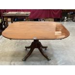 A mahogany breakfast table on ring turned column and quadripartite outswept support. 54' wide.