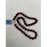 A necklace of dark red amber beads. 20' long. 26g gross