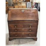 An 18th century oak writing bureau, the sloping fell enclosing a fitted interior with well, over two