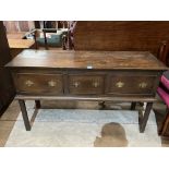 An oak dresser base with three drawers, raised on chamfered square legs. 54' wide