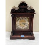 An early 20th century walnut mantle clock, with two train brass movement striking on a coiled