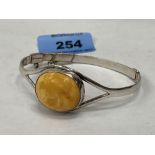 A silver openwork bangle set with a yellow agate stone