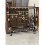 A Victorian 4'6' iron and brass bedstead, the lot to include a pitch pine and mesh base. Some