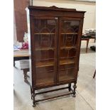 A 1930s oak bookcase enclosed by a pair of banded glazed doors. 36'w x 56'h