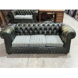 A three seater chesterfield sofa upholstered in deep buttoned green leather. 74' wide