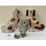 Two 19th century Staffordshire iron red and white glazed spaniels, 13' high; together with a