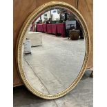 An early 20th century gilt framed oval mirror with bevelled plate. 44' x 34'