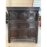 A 17th century joined oak court cupboard with carved cornice raised on turned pilasters flanking a