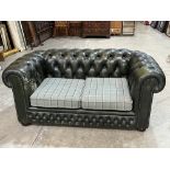 A chesterfield sofa, upholstered in deep buttoned green leather. 62' wide