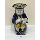 A late 18th century/early 19th century pearlware Toby jug, the character holding a pitcher and glass