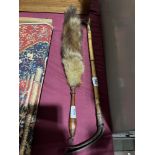 A riding crop and a fox tail brush