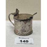 An Edward VII silver mustard pot with blue glass liner and silver spoon. Chester 1909. Marks rubbed.