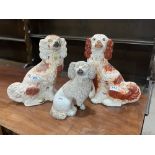 Two 19th century Staffordshire iron red and white glazed spaniels, 13' high; together with a