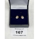 A pair of 18ct white gold diamond stud earrings, each set with a point 10 stone. 1.85g gross