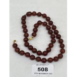 A neclace of dark red amber beads. 20' long. 26g gross