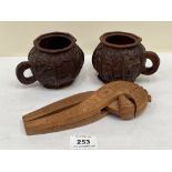 A pair of carved treen mugs, 3¼' high; together with a carved treen nutcracker, 8' long