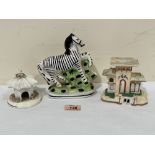 A 19th century Staffordshire Zebra (head re-stuck) 6¼' high and two cottage pastille burners (3)