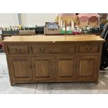 A joined oak sideboard with three drawers over four panelled doors. 72' wide