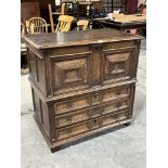 A late 17th century oak chest in two parts, the upper part with moulded lid and panelled front, over