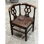 A joined oak corner chair with tracery splats and woven leather drop-in seat