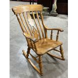 A rocking armchair, the lath back with shaped splat, the seat in elm