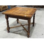 A 1930s oak drawleaf dining table on barleytwist legs. 59' long extended