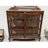 A bowfronted mahogany china display cabinet enclosed by a pair of astragal glazed doors. 48' wide.