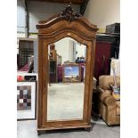 A 19th century French walnut armoire, enclosed by a bevel glazed door under a carved surmount. 38'