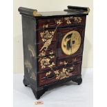 A Japanese gilded and painted lacquer table cabinet fitted with ten drawers and a pair of doors.