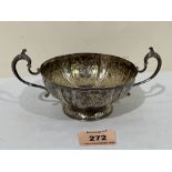 An Elizabeth II silver foliate chased bowl with scrolled handles and domed font. Birmingham 1977. 7'