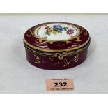 A Limoges porcelain oval box, gilded and painted with a spray of summer flowers on a rougue-royale