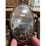 An Edward VII mahogany and inlaid oval wall mirror with bevelled plate. 37' high