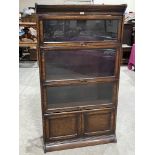 An oak sectional bookcase in the glazed parts over a cupboard base. 34'w x 62'h