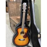 A Freshman acoustic guitar, sunburst body, with strap and hard case. 40' long