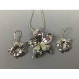 A SILVER FLOWERHEAD PENDANT ON CHAIN ALONG WITH A PAIR OF MATCHING EARRINGS