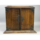 AN EARLY 20TH CENTURY OAK SMOKER'S CABINET AND A DOULTON BOTTLE VASE