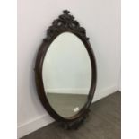 AN OVAL BEVELLED WALL MIRROR