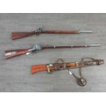A REPRODUCTION FLINT LOCK MUSKAT, A REPRODUCTION PERCUSSION RIFLE AND A WALL MOUNTING RIFLE