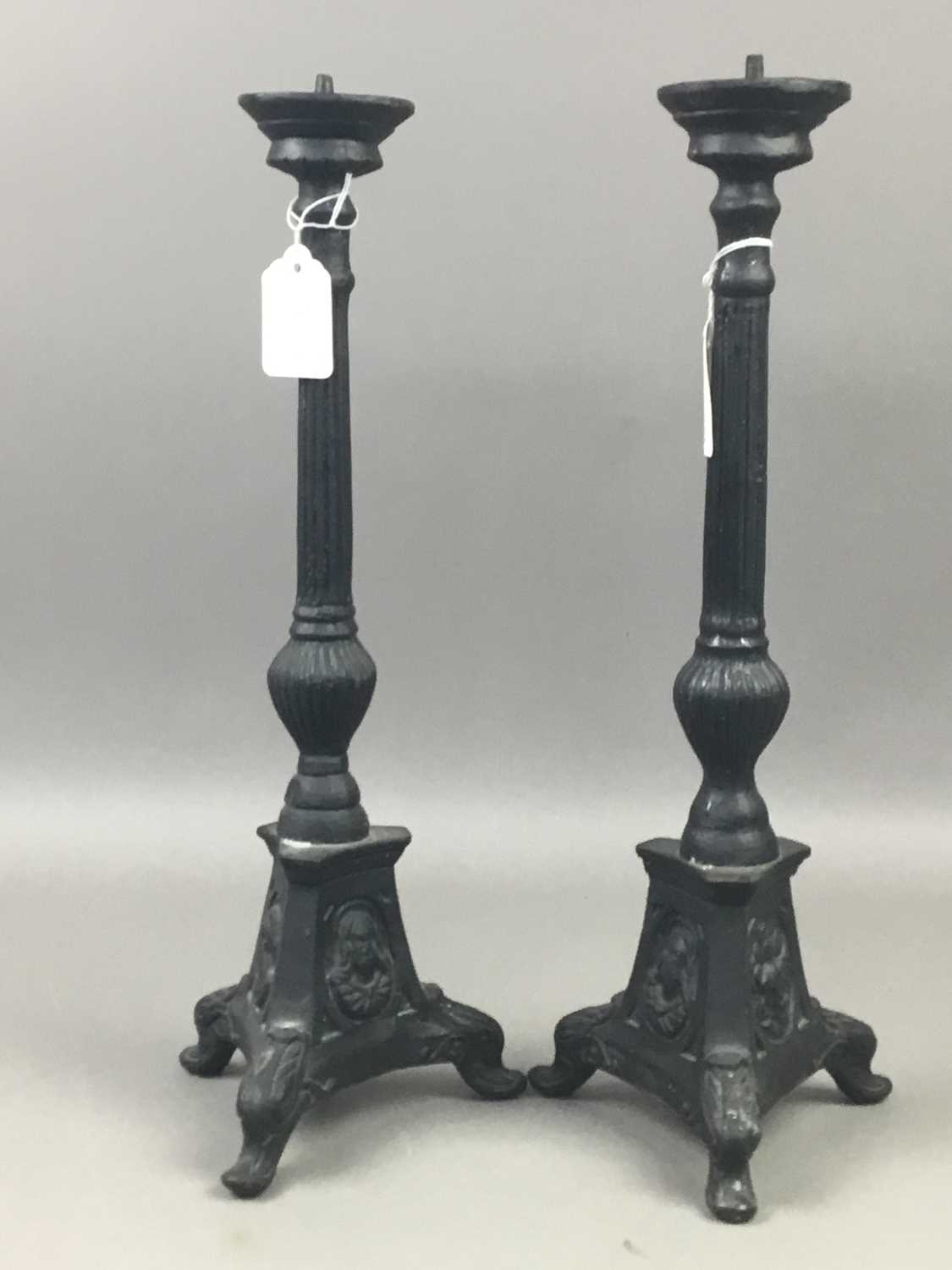 A PAIR OF CAST IRON CANDLESTICKS AND A FIRE COMPANION