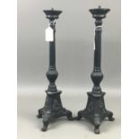 A PAIR OF CAST IRON CANDLESTICKS AND A FIRE COMPANION