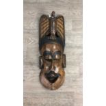 AN AFRICAN CARVED MASK AND TWO STOOLS