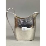 A GEORGE III SILVER CREAM JUG