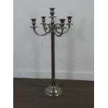 A STAINLESS STEEL FOUR BRANCH CANDELABRUM, ANOTHER SMALLER CANDLEABRUM AND A CAKESTAND