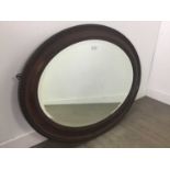 A MAHOGANY OVAL WALL MIRROR