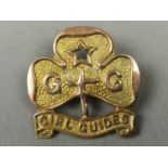 A NINE CARAT GOLD GIRL GUIDES BADGE