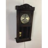 AN OAK CASED WALL CLOCK