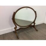 AN OVAL MAHOGANY DRESSING MIRROR