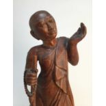 A MID 20TH CENTURY CARVED TEAK FIGURE OF A BUDDHIST MONK