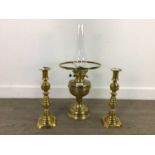 A BRASS OIL LAMP AND A PAIR OF CANDLESTICKS