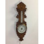 A VICTORIAN OAK ANEROID WHEEL BAROMETER AND THERMOMETER